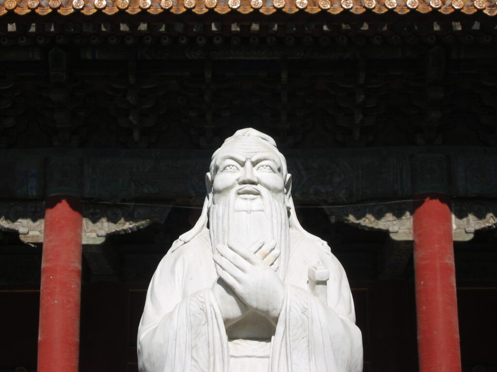 White marble statue of Confucius with clasped hands at the Confucian Temple in Beijing