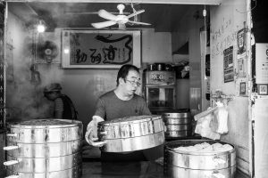 Steamed baozi buns in a bamboo basket on a breakfast table