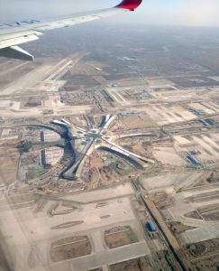 Aerial view of Beijing Daxing International Airport terminal from an airplane window