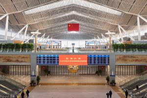 Crowded waiting hall inside Beijing Chaoyang Railway Station with passengers and departure boards