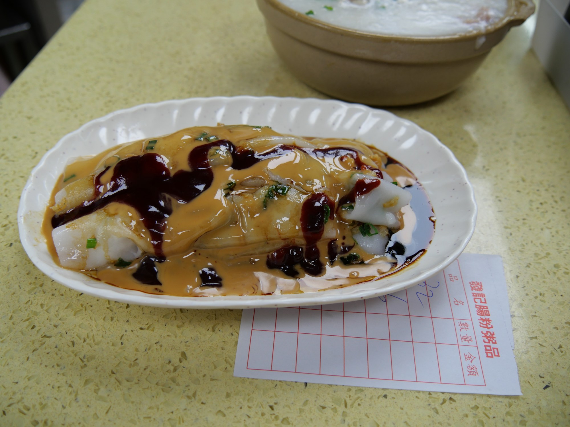 White Cantonese rice noodle rolls with shallots, peanut sauce, and savory dressing