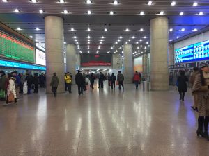 Ticket hall interior at a major China railway station with counters and waiting passengers