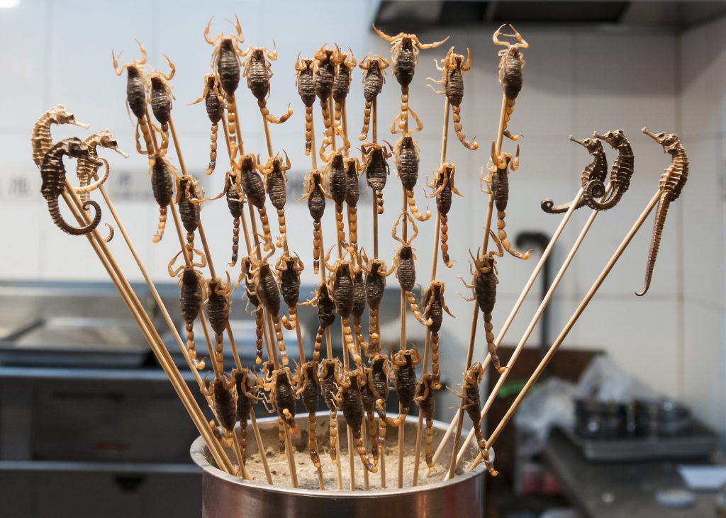 Assorted Chinese barbecue skewers grilling at a Beijing night market stall