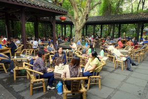 Guests seated at bamboo chairs and tables in an outdoor teahouse in Peoples Park, Chengdu