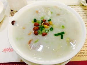 Bowl of Cantonese sampan congee with toppings served as a Chinese breakfast porridge