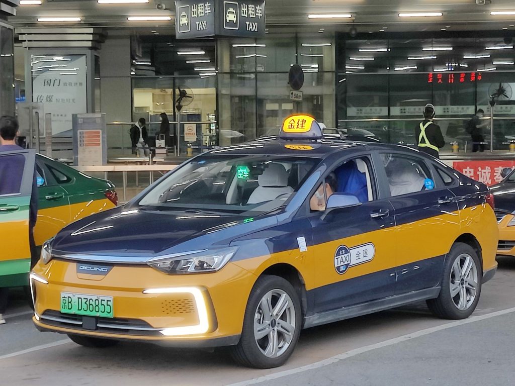 Yellow taxi at a Shanghai railway station pickup area