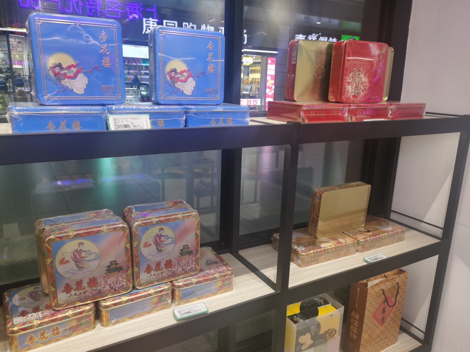 Stacked tin boxes of Shanghai Xing Hua Lou mooncakes on a shop shelf