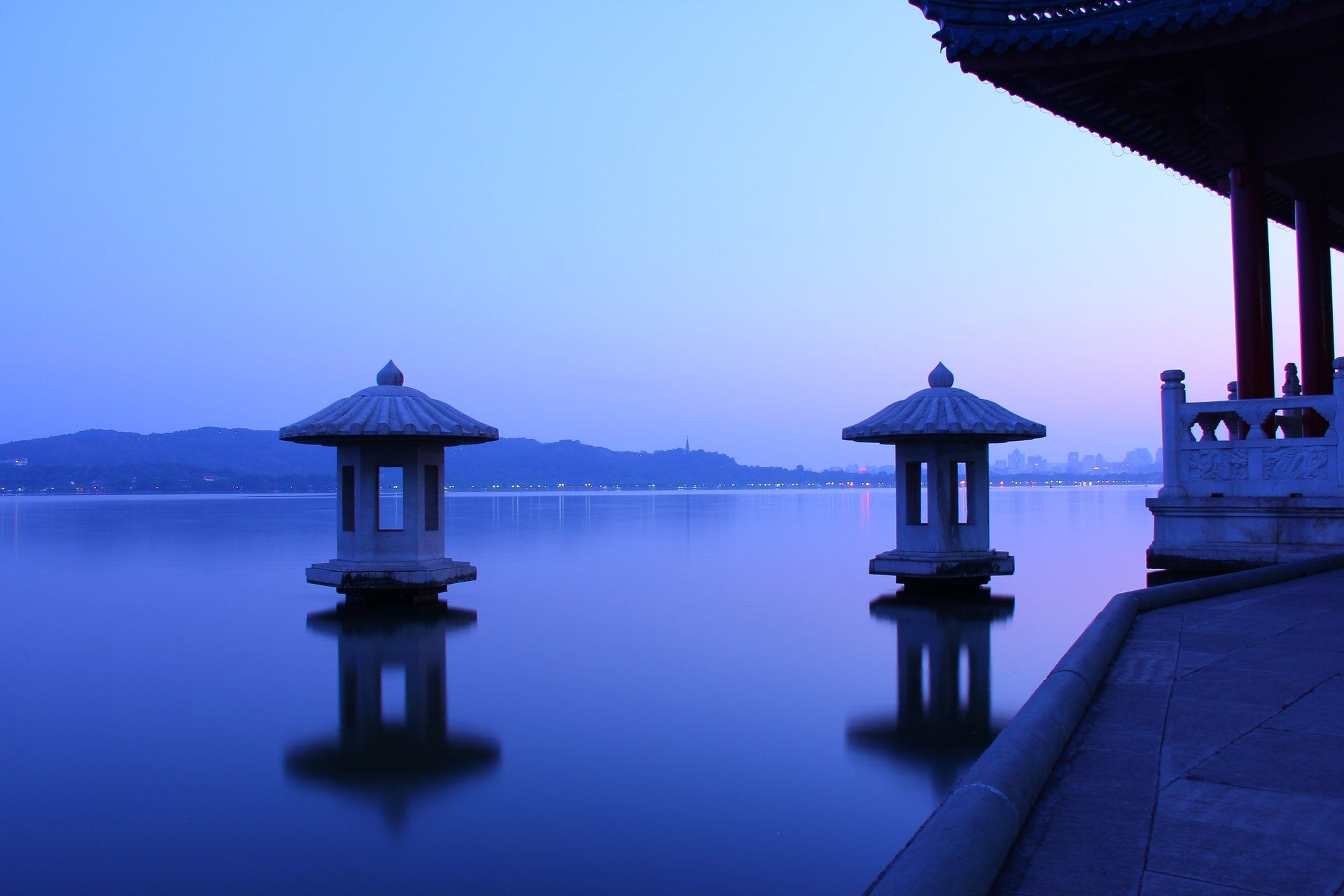 Autumn moon over calm West Lake with lakeside lights in Hangzhou