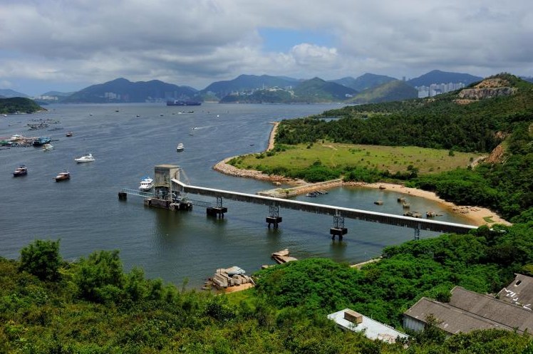 Coastal pier and green hills on a Hong Kong shore