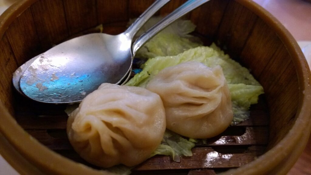 Close-up of steamed xiaolongbao soup dumplings in a bamboo steamer