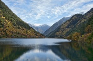 Turquoise Rhino Lake in Jiuzhaigou Valley with forested mountains and clear reflections