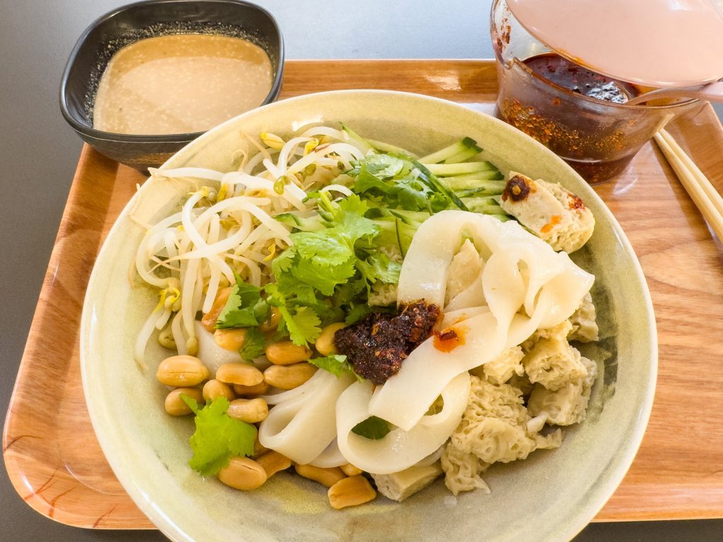 Plate of sesame liangpi cold noodles with cucumber and sauce