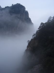 Fog curling around pine-covered peaks of Mount Lushan in Jiangxi