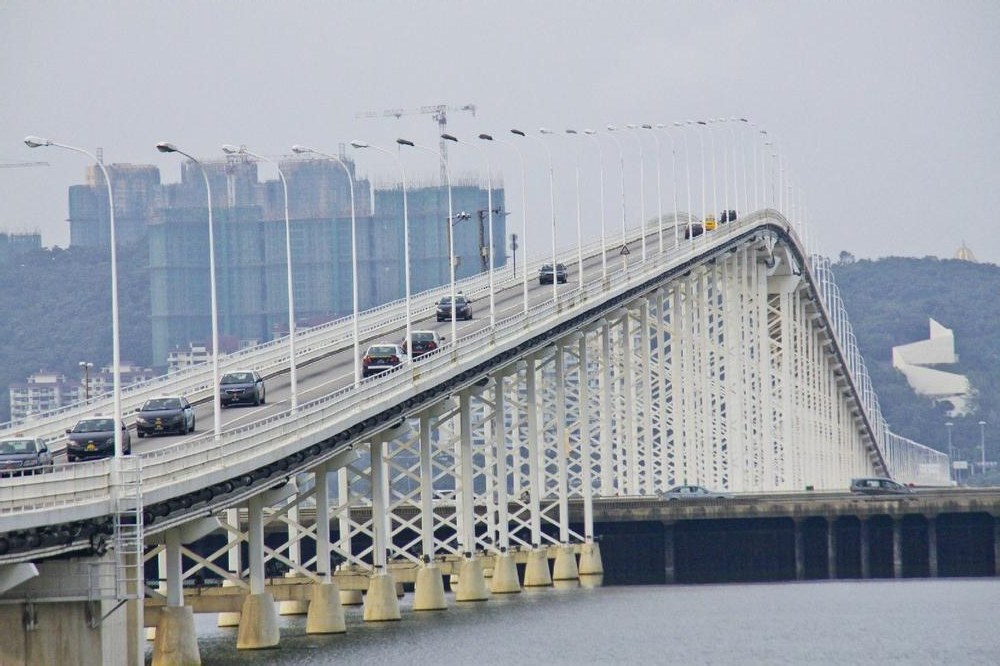 Arched Macau–Taipa bridge crossing the water toward high-rises