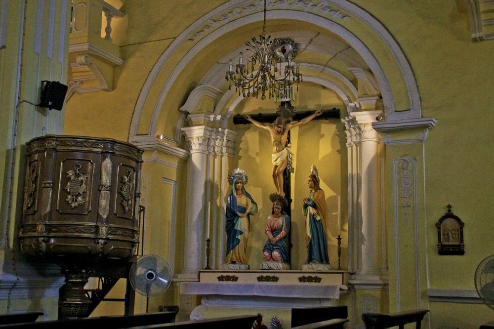 Historic Catholic church interior with crucifix and statues in Macau
