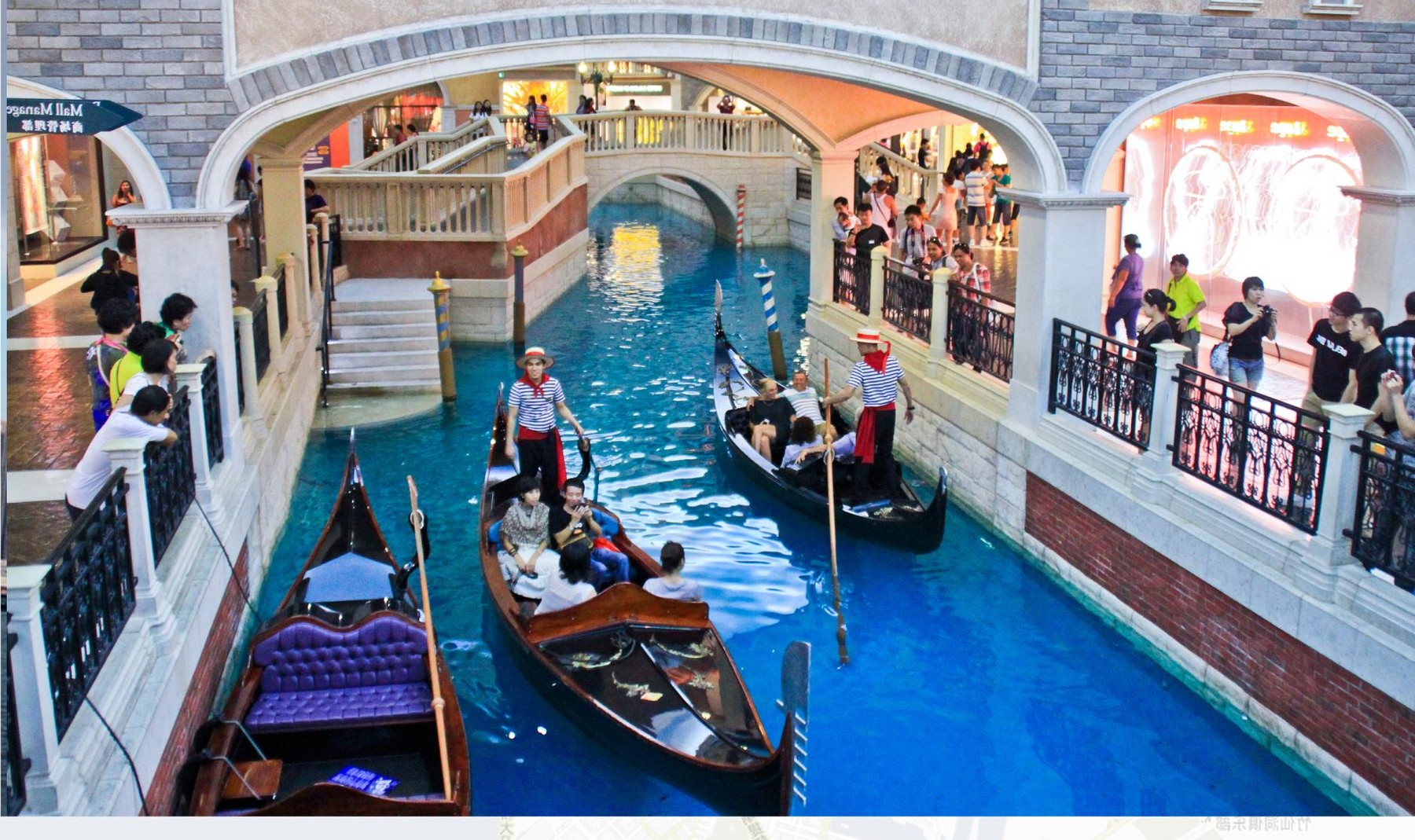 Gondolas on the blue indoor canal inside The Venetian Macao