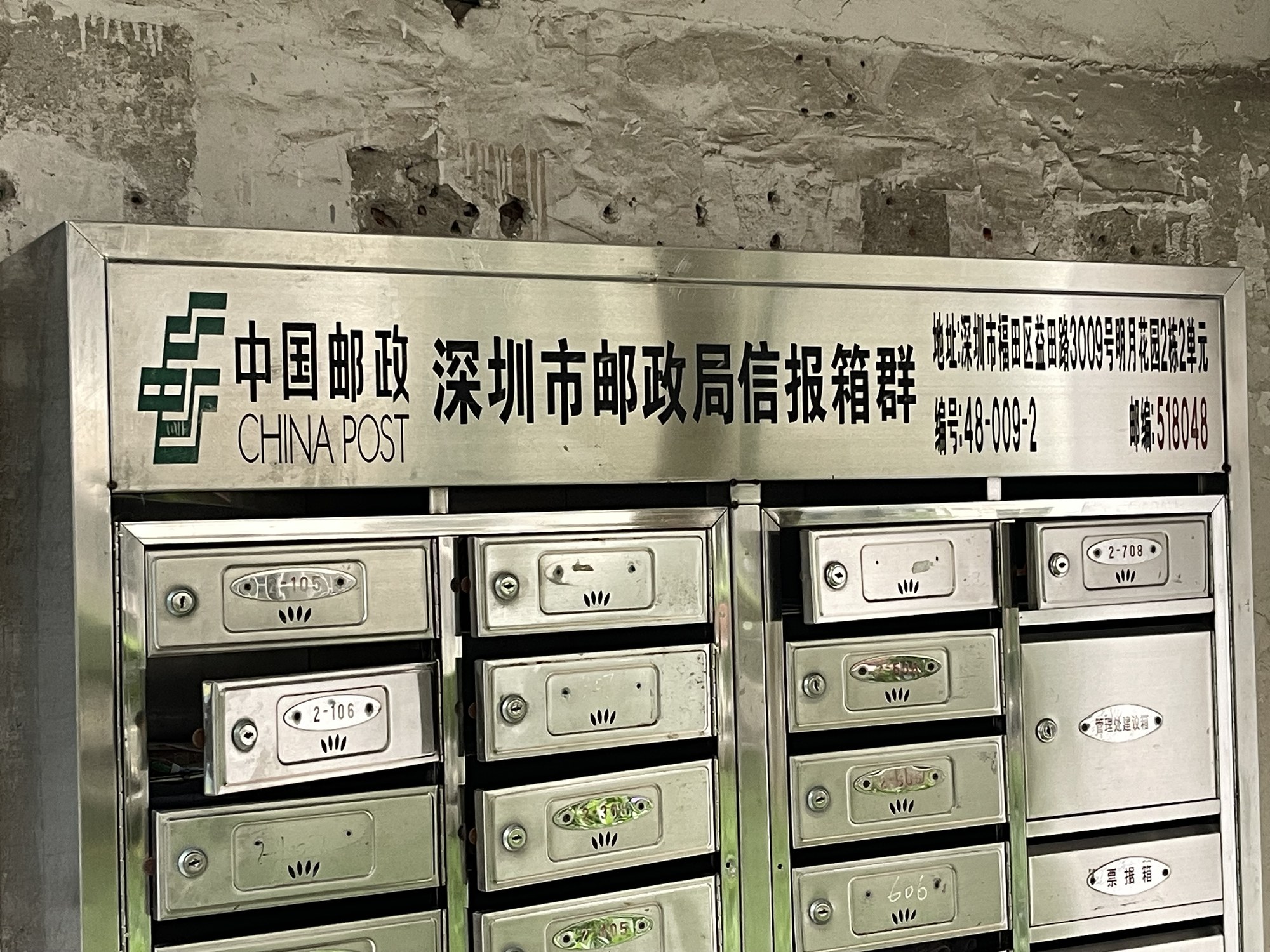 Row of red China Post mailboxes along a city street for sending parcels abroad