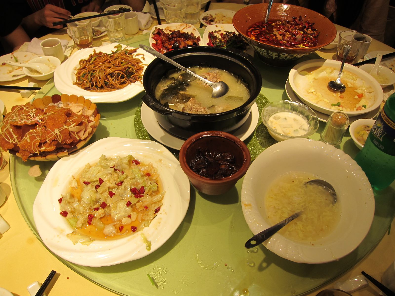 Chinese restaurant table setting with shared dishes on a lazy Susan turntable.