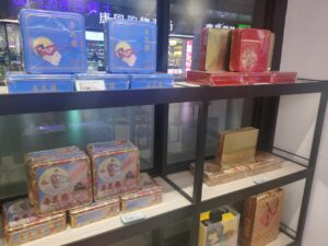 Stacked Xing Hua Lou mooncake tin gift boxes on sale at a Shanghai station counter