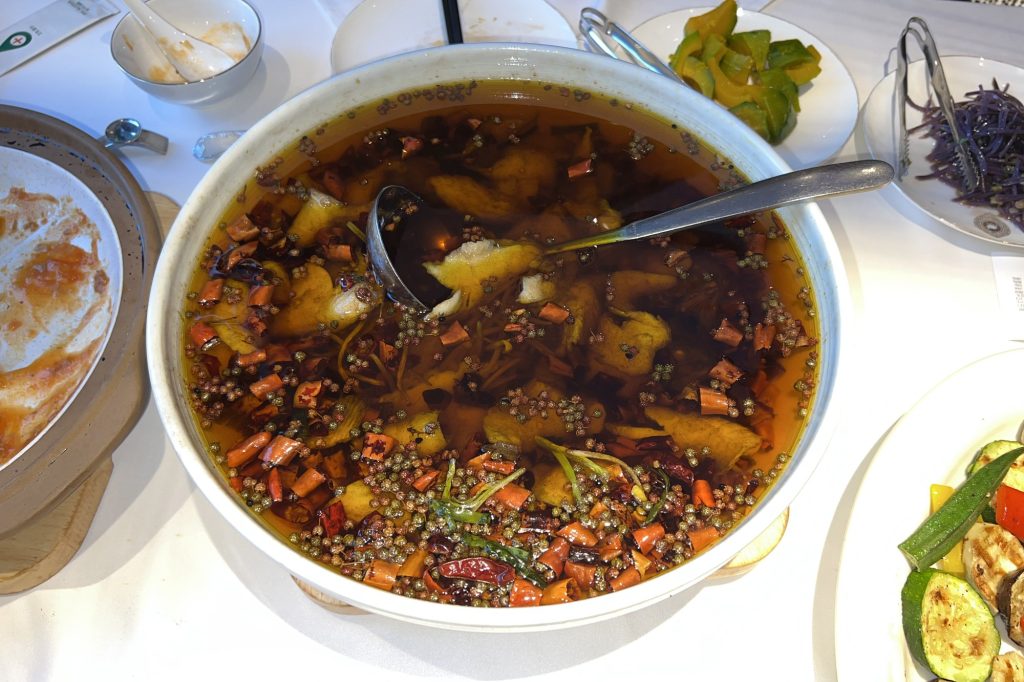 Sichuan boiled fish in chili oil (shuizhu yu) in a large bowl with chili and bean sprouts
