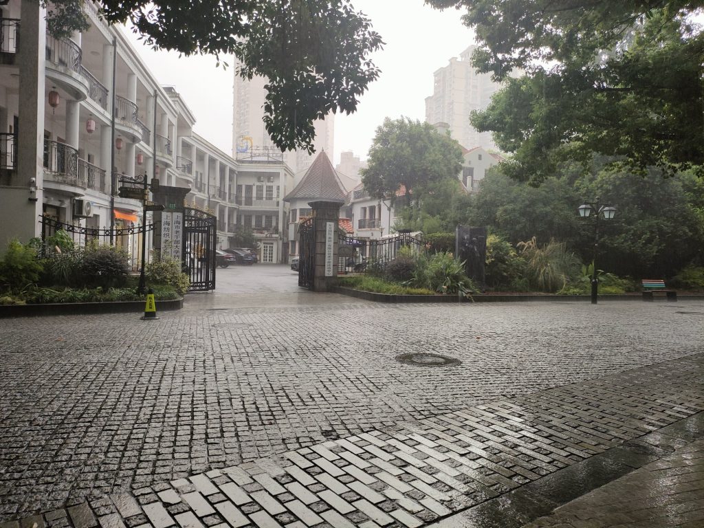 Heavy rain and typhoon weather on a Shanghai street with umbrellas