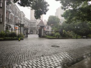 Heavy rain and typhoon weather on a Shanghai street with umbrellas