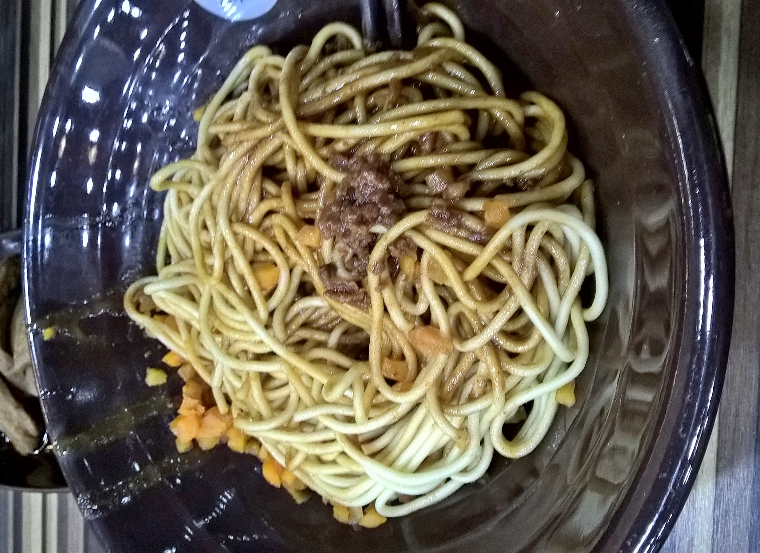 Bowl of Wuhan hot dry noodles with sesame sauce and toppings
