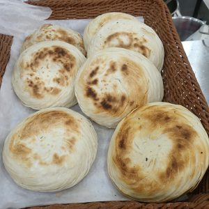 Xi'an-style roujiamo meat sandwich cut open on a plate