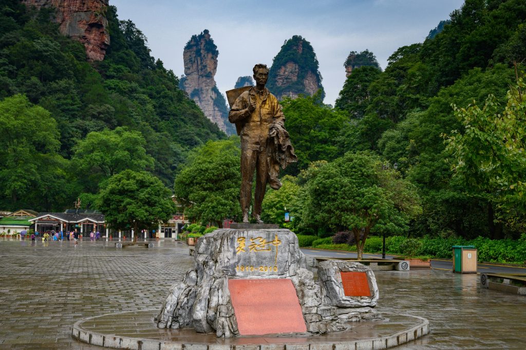 Tall sandstone pillars and forested peaks in Zhangjiajie National Forest Park under a bright sky